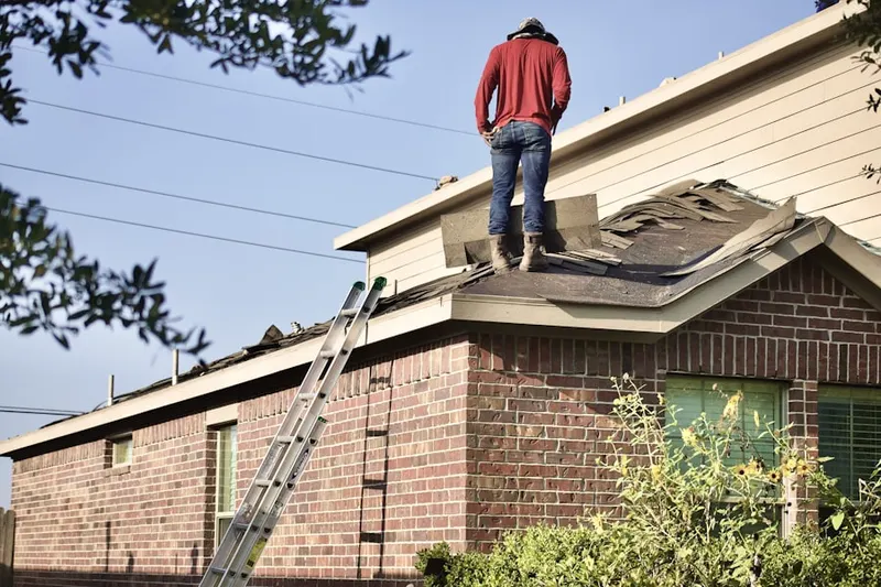 Professional roofer working on a residential roof in Poplar Grove